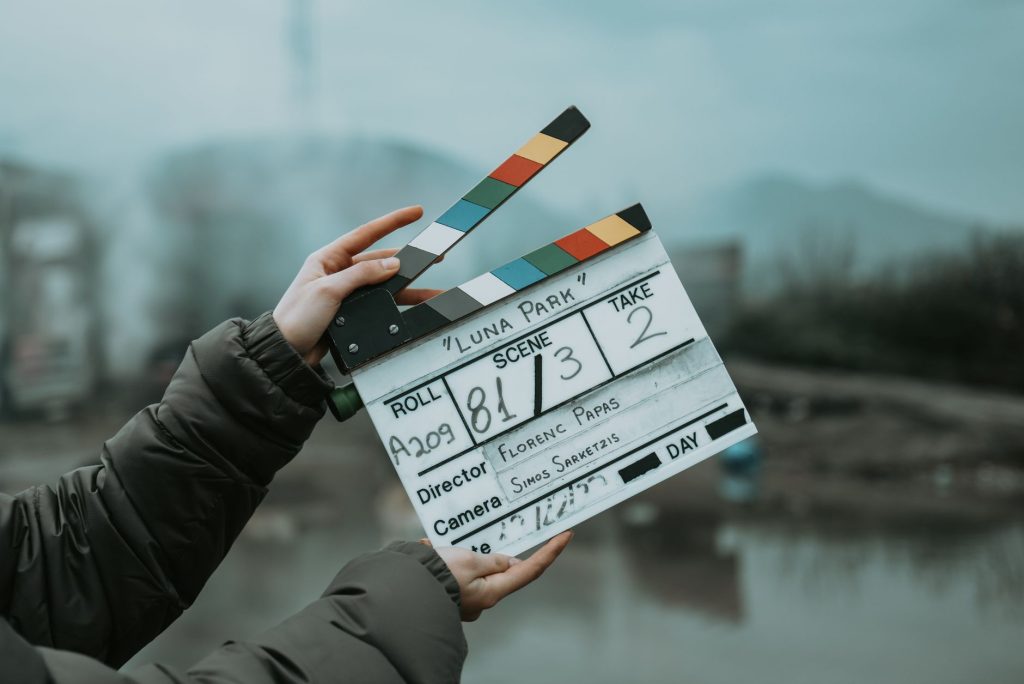 Main tenant un clap de cinéma sur un lieu de tournage en extérieur