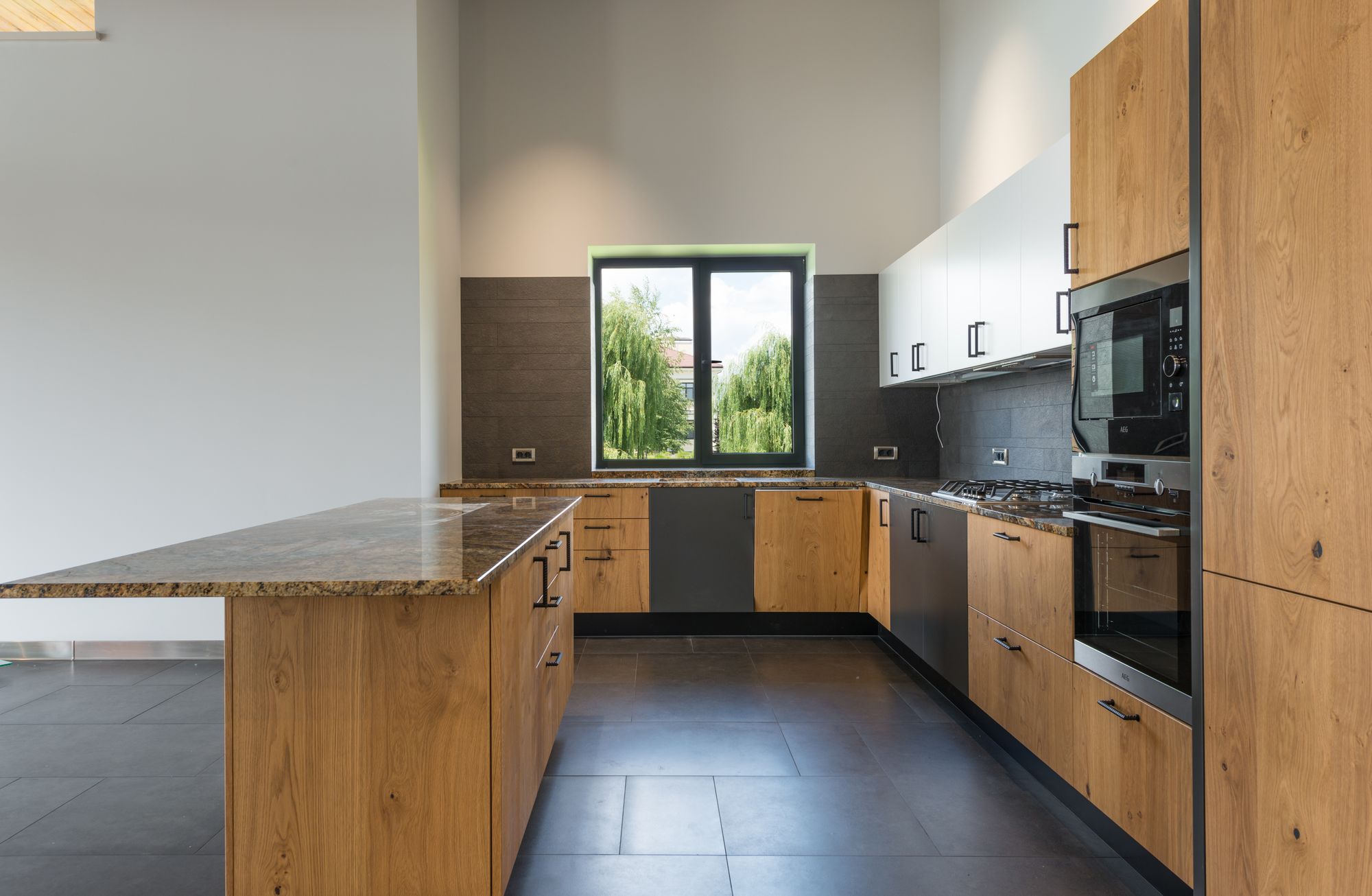 Cuisine équipée moderne en bois avec plan de travail et fenêtre sur le jardin