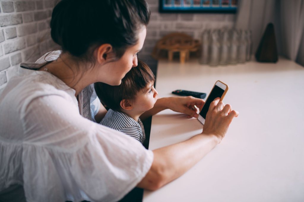 Une mère et son enfant regardent ensemble un smartphone