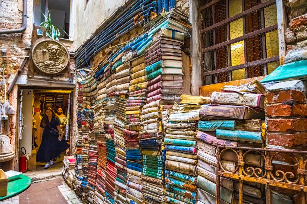 Ruelle de la librairie Acqua Alta à Venise, avec des piles de livres colorées