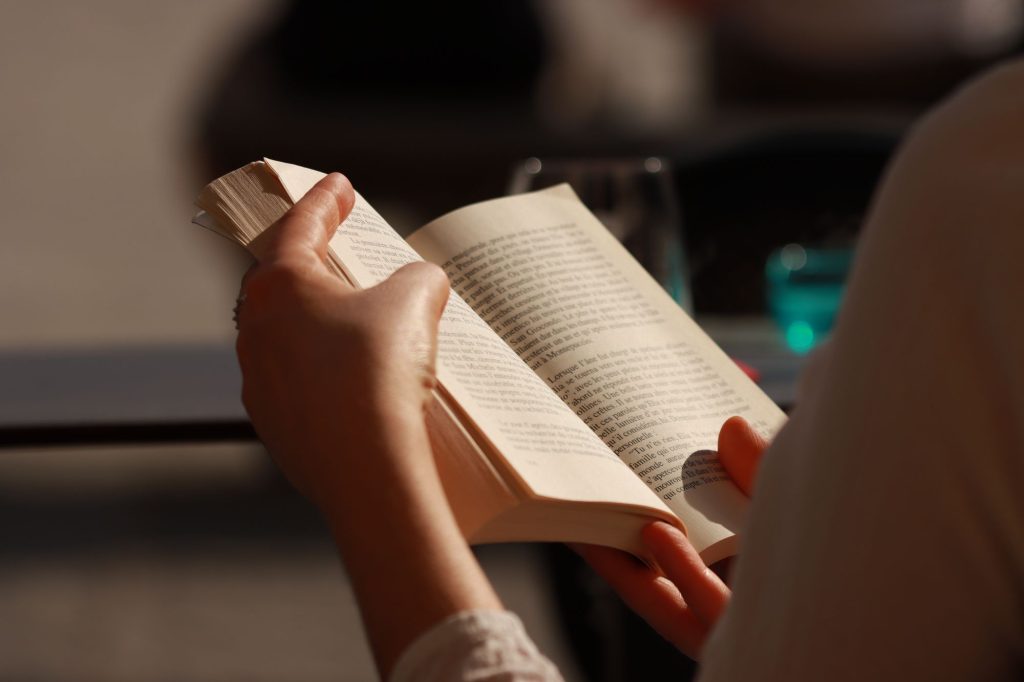 Gros plan sur des mains tenant un livre de poche ouvert