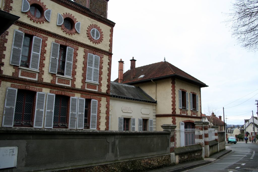 La maison d'Émile Zola à Médan vue depuis la rue, avec sa tour à horloge et ses façades en briques