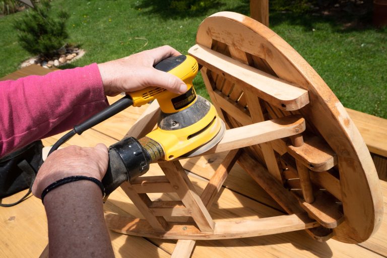 Ponçage d'une table en bois à la ponceuse pour restaurer un vieux meuble