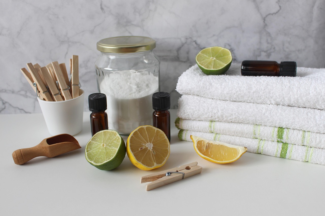 Bicarbonate de soude, citrons, savon et brosse posés sur un plan de travail pour le ménage au naturel