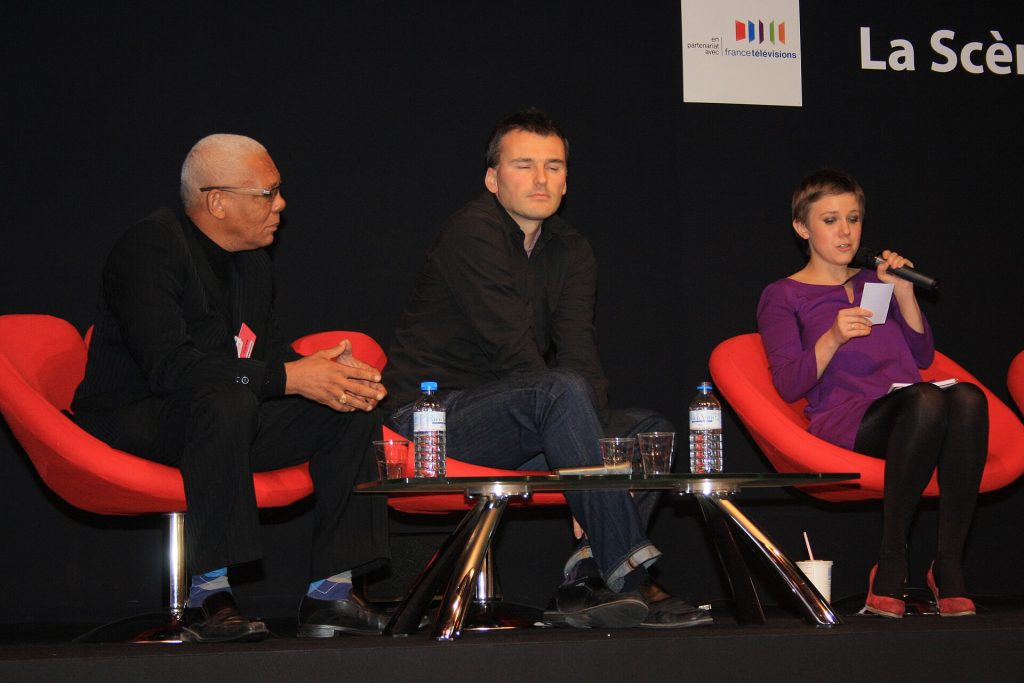 Rencontre d'auteurs sur la scène du Salon du livre de Paris, assis dans des fauteuils rouges