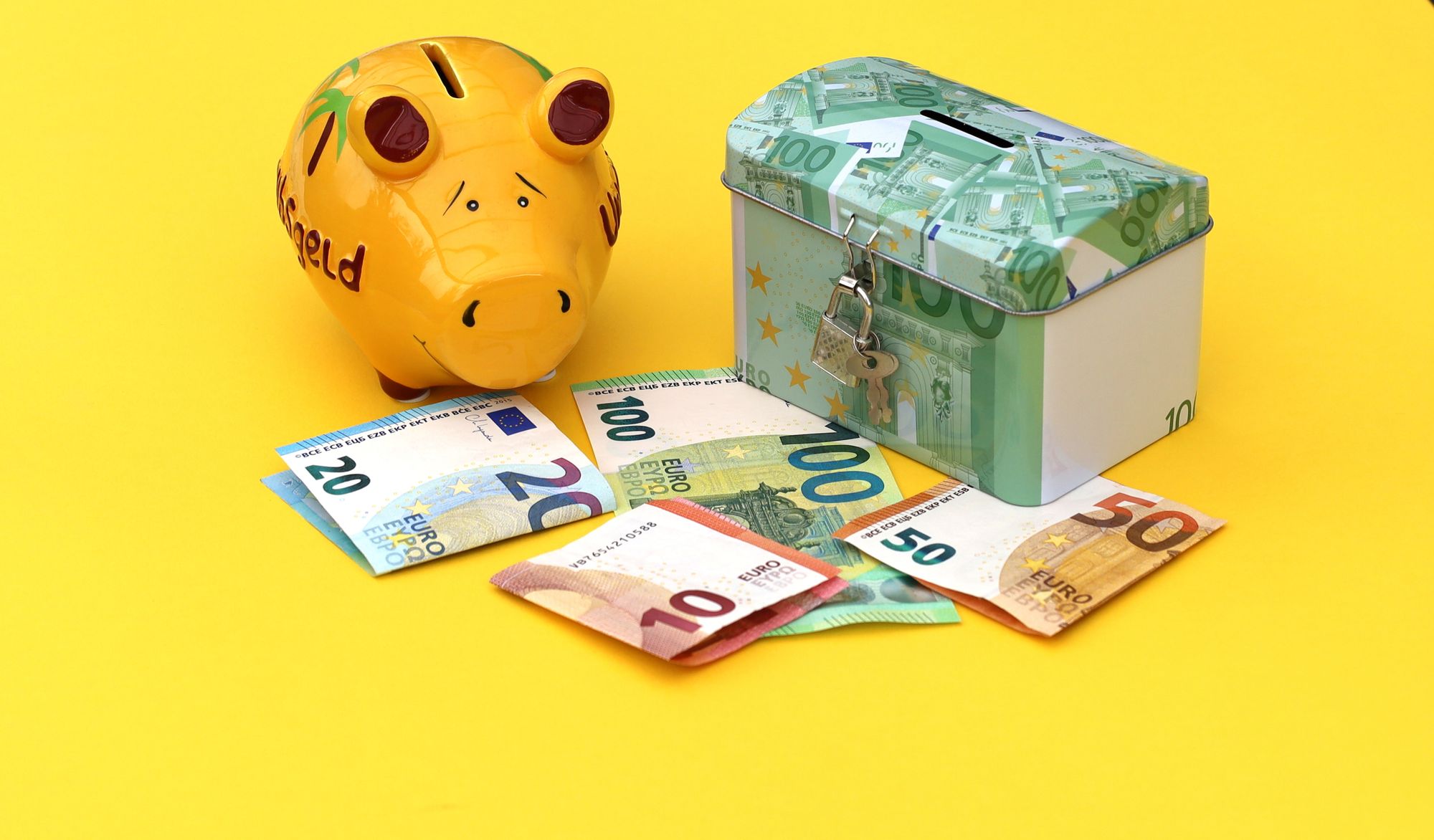 Tirelire jaune, boîte à économies et billets en euros sur fond jaune vif