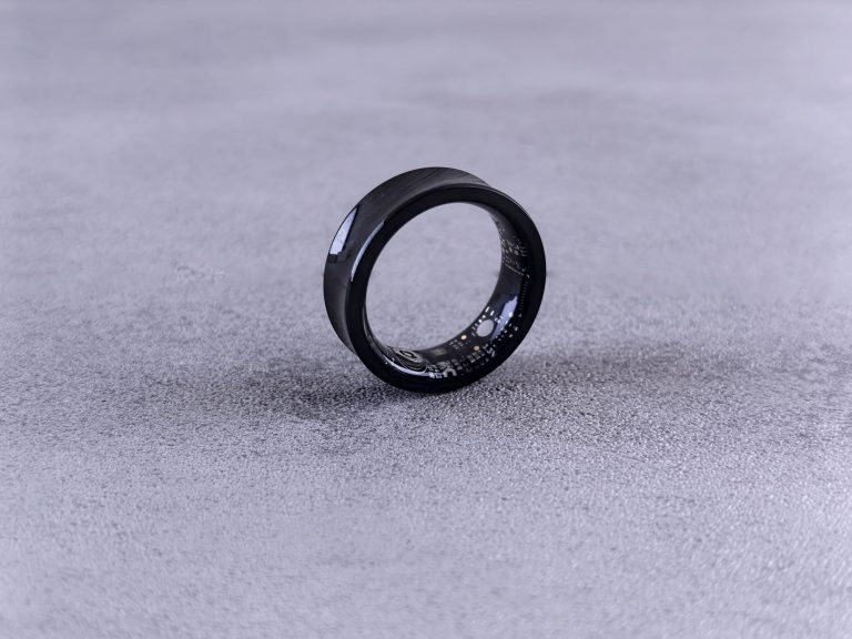 Bague connectée noire posée sur une surface grise, objet de suivi du sommeil