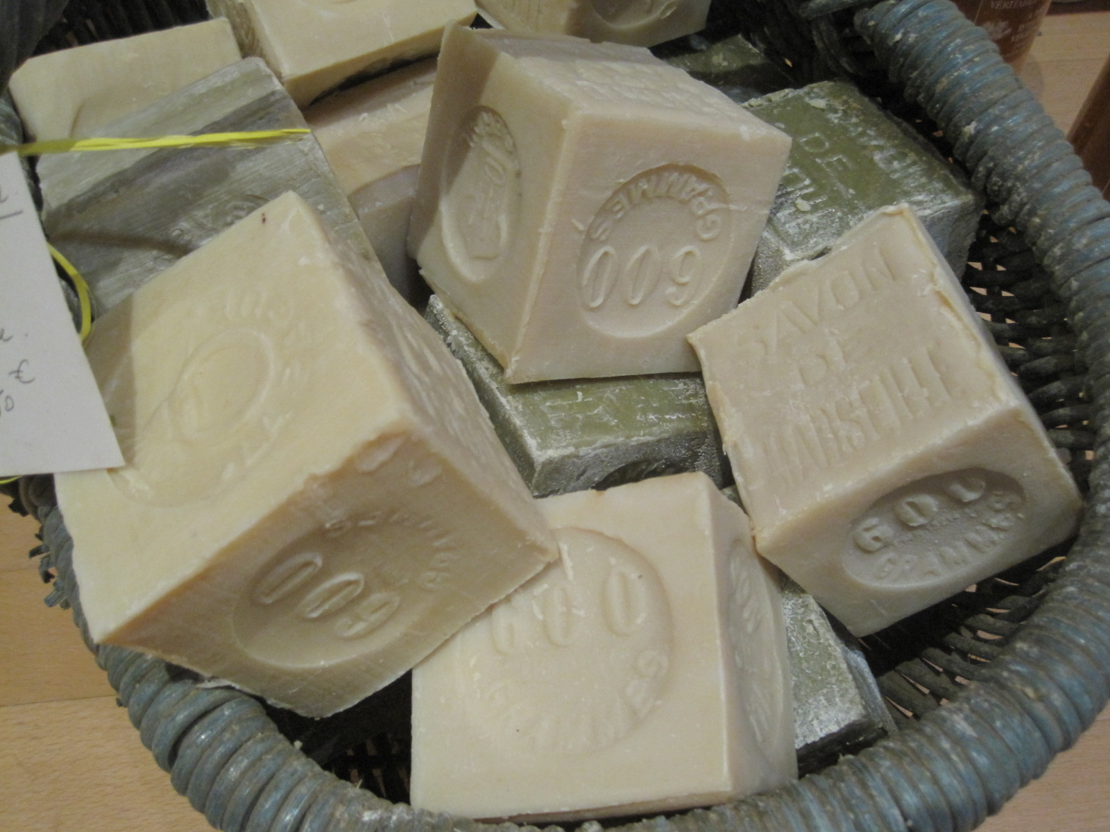 Cubes de savon de Marseille blancs et verts empilés dans un panier en osier